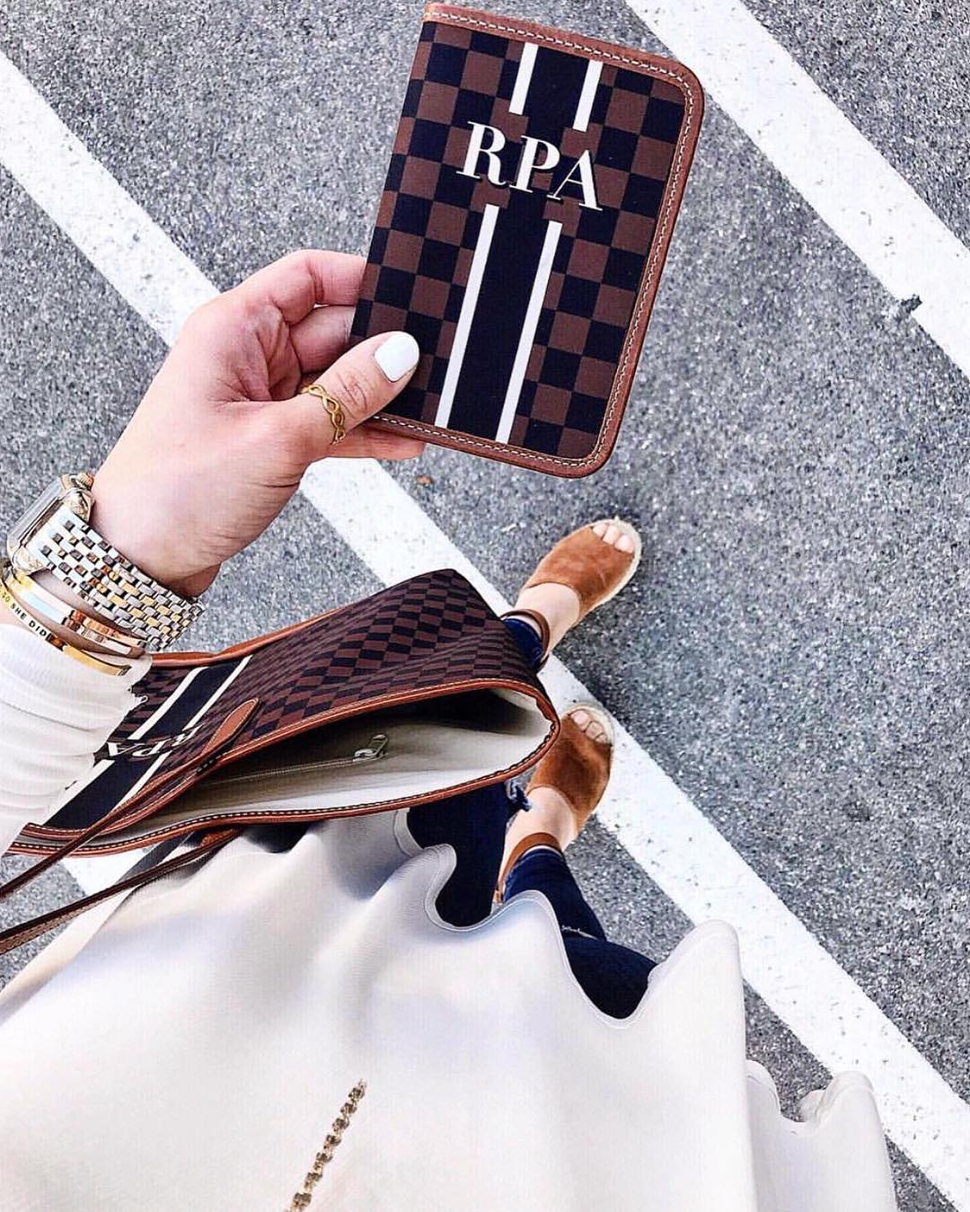 Sophisticated brown checkered passport cover with monogram, a timeless piece for global adventures.