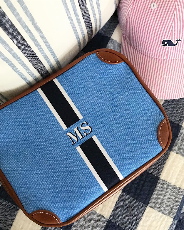 Blue striped monogrammed cosmetic bag on fabric