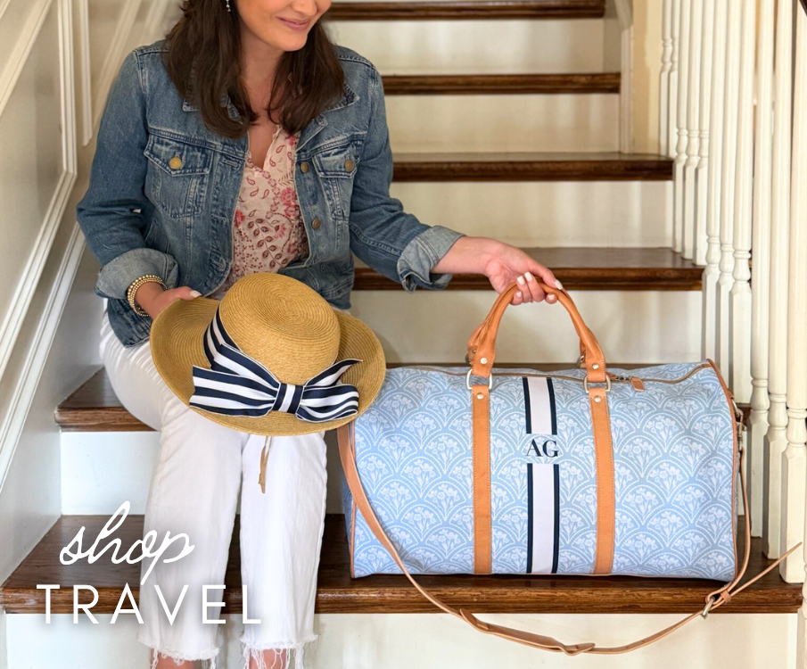 Girl sitting on the stairs with a Blue Floral Fans with Navy/White monogram stripe Belmont Cabin Bag in Blonde leather trim.