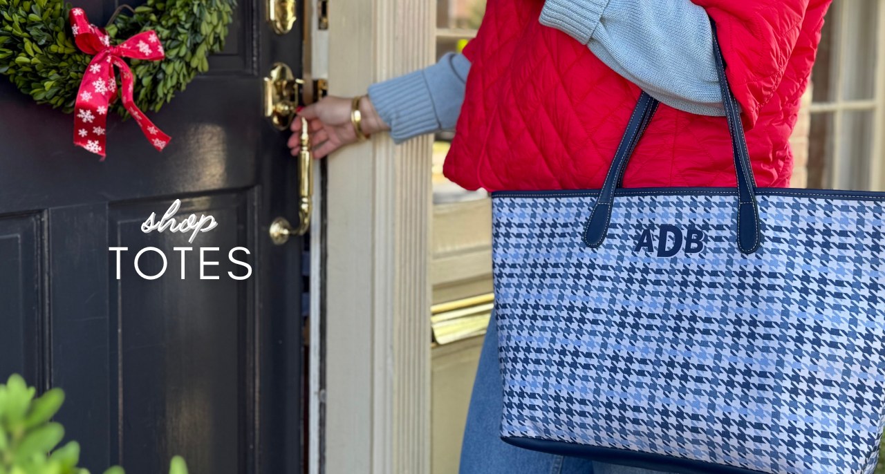 Woman carrying blue houndstooth monogrammed tote bag with personalized initials at home entrance during winter